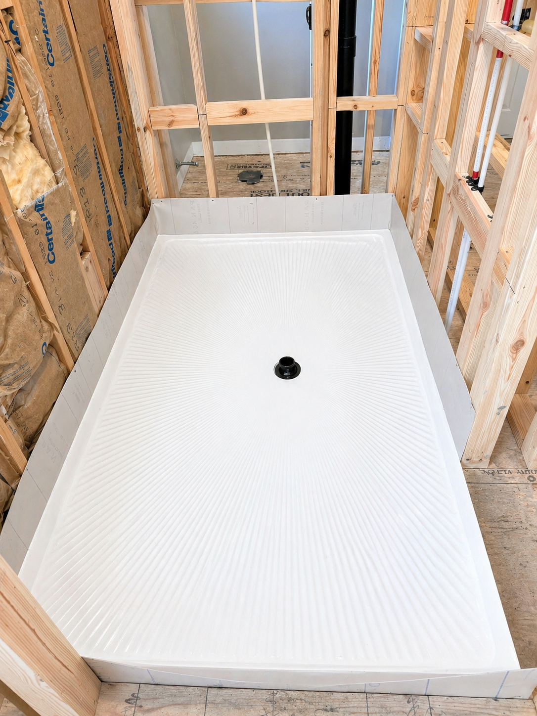 Quartz shower pan drop-in installation with waterproof liner